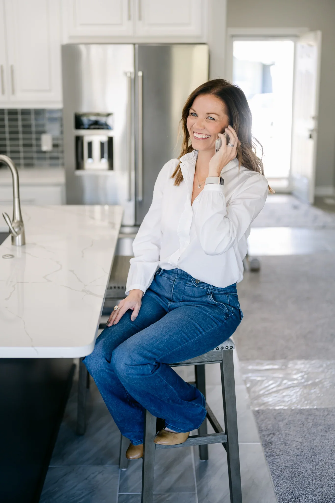 Anne M. Steele taking a call in a kitchen