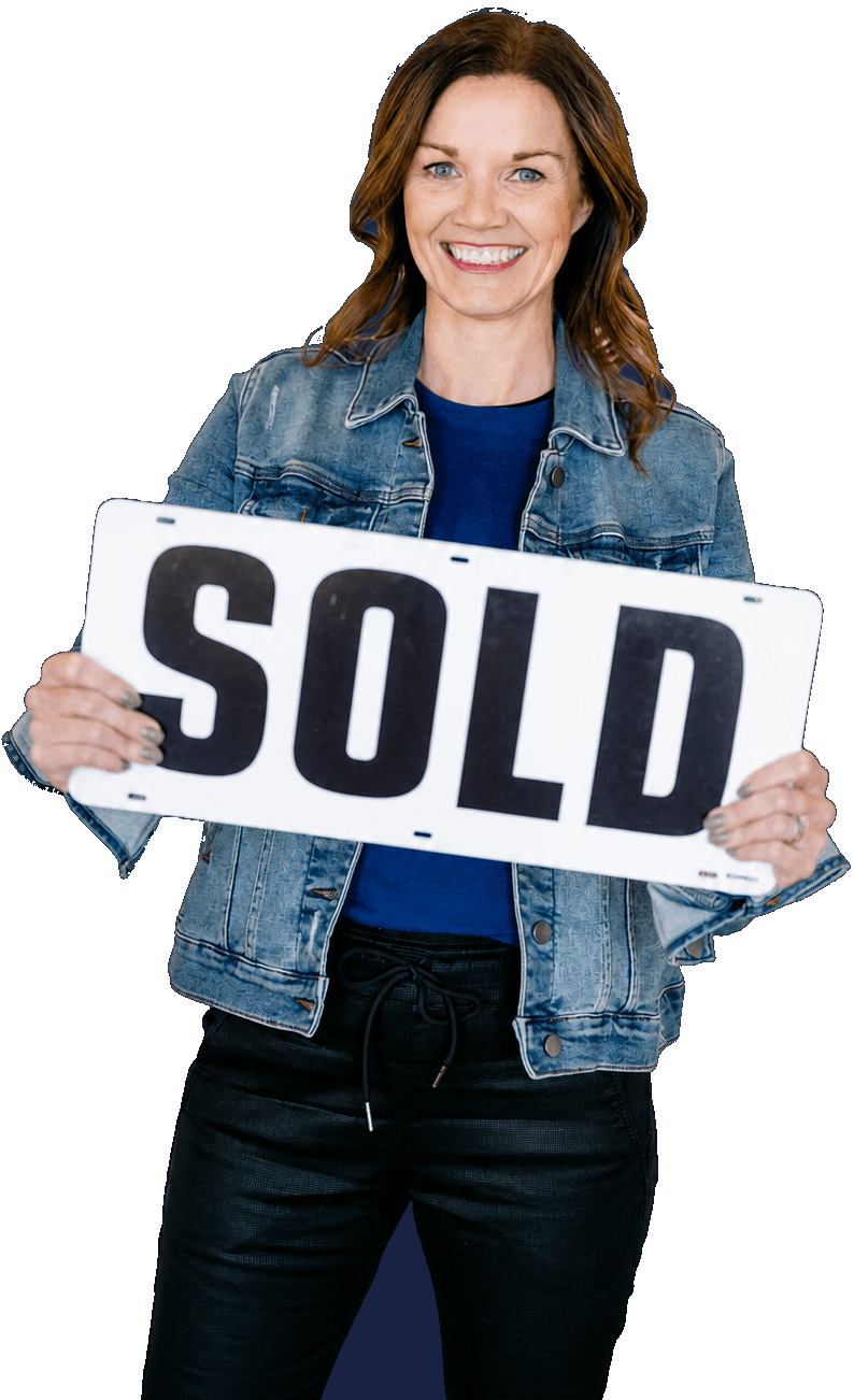 Anne M. Steele holding a Sold sign